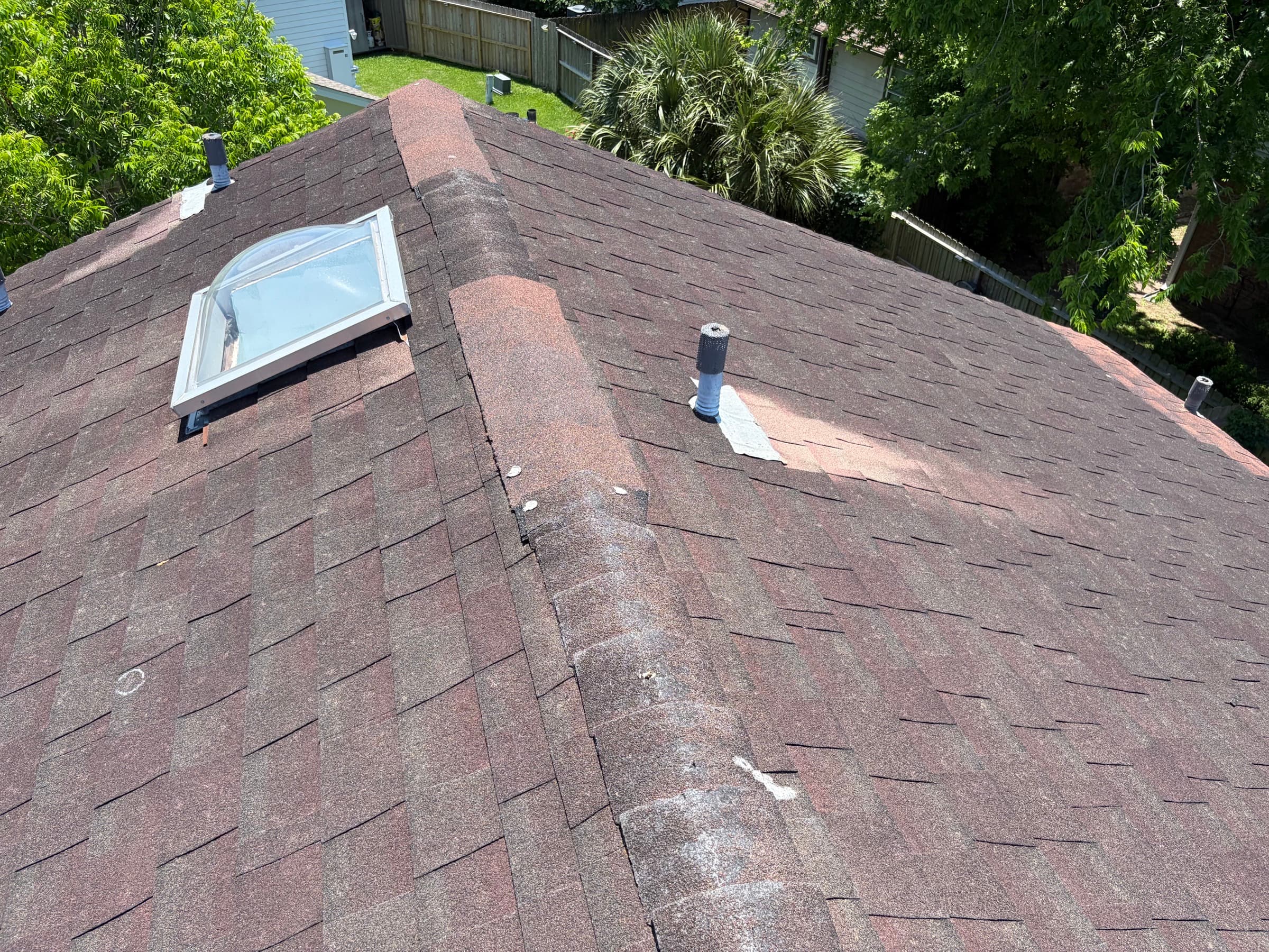 Roof inspection documenting damage around a skylight, marked for an insurance claim